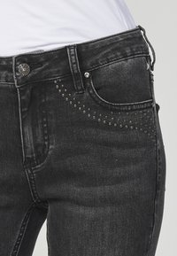 Koroshi FLARED - Pieguloša piegriezuma džinsi - black denim