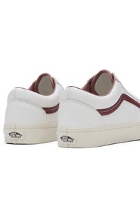 Paire de baskets Vans basses blanches avec un détail de bande bordeaux et le logo "Vans Off The Wall" sur des semelles de couleur crème, vues de derrière.