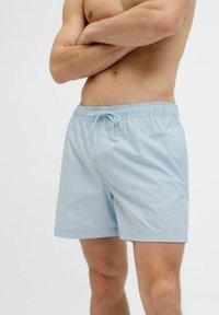Lichtblauwe zwemshorts met elastische tailleband en trekkoord. Glad, lichtgewicht materiaal, knielang, met zijzakken.