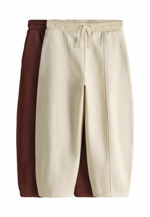 Due paia di pantaloni in pile, uno crema e uno marrone, con cintura elastica e cuciture frontali, impilati con il crema davanti.