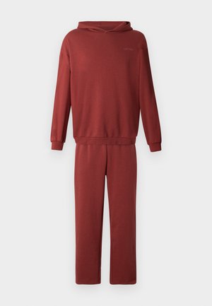 Completo jogging in cotone rosso con felpa con cappuccio e pantaloni abbinati. Presenta una vestibilità comoda e polsini elasticizzati su maniche e caviglie.
