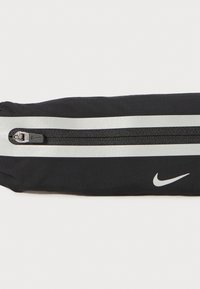 Zwarte stoffen etui met zilveren dubbele strepen, uitgerust met een ritssluiting en een klein wit Nike-logo. Gladde textuur en gestroomlijnd ontwerp.