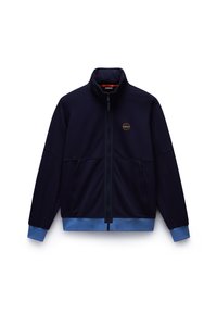 Marineblå zip-jakke med høy krage, blå detaljer ved mansjetter og nederkant, med to frontlommer og en sirkulær logo på brystet.