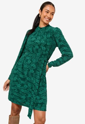 Grünes Kleid mit Blumenmuster, langen Ärmeln und tailliertem Bund. Hergestellt aus strukturiertem Stoff mit einer figurbetonten Silhouette.