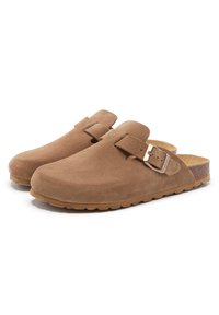 Sabots en suède marron avec un orteil courbé, une sangle réglable et une semelle en liège. Semelle texturée et finition douce. Pas de marque visible.