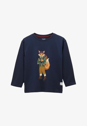 Marineblå langærmet skjorte med en tegneseriefigur af en ræv iført hue, ternet skjorte, rygsæk og vandrestøvler trykt på forsiden.