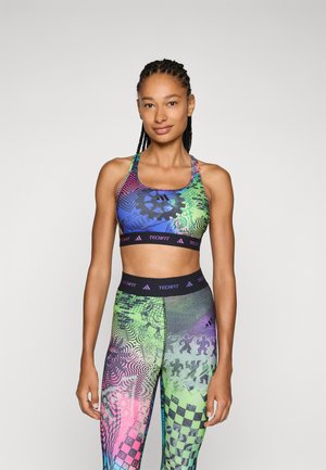 Colorful athletic set featuring a patterned sports bra and matching leggings. Material is stretchy with various graphic designs in vibrant shades.