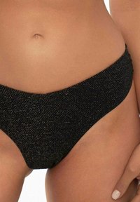 Czarne bikini dolne z teksturowanym, błyszczącym materiałem, niskim stanem i umiarkowanym kryciem, podkreślające smukły i wyprofilowany kształt.