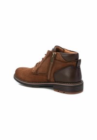 Botas de ante marrón hasta el tobillo con acentos de cuero, puntera redonda, diseño de cordones y cremallera lateral. Suela resistente con un ligero tacón.
