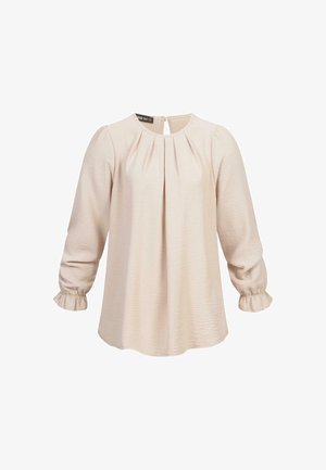 Blusa a maniche lunghe di un leggero beige con fronte plissettato, scollatura rotonda e polsini con balze. Tessuto morbido e testurizzato con una leggera lucentezza.
