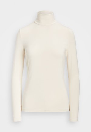 Haut à manches longues en tissu doux de couleur crème. Présente un design ajusté avec un col montant et des bords de manches sans couture.