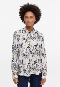 Long-sleeve shirt in lightweight fabric featuring a swirling abstract pattern in navy, beige, and cream. Button-up front with collar.