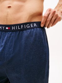 Pantaloni de lounge dintr-un amestec de bumbac de culoare bleu marin, cu un brâu elastic ce prezintă logo-ul "Tommy Hilfiger"; textură moale și design casual.
