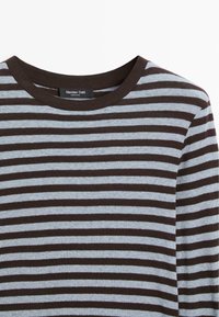 Stripet strikket sweater med brune og lyseblå horisontale striber, rund halsudskæring og ribbet detaljer ved kraven, blød tekstur.