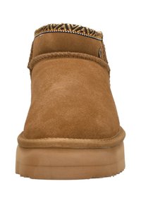 Bruine suede enkellaars met een ronde neus, decoratieve parelrand rond de kraag en een rubberen zool. Glad materiaal op de bovenkant.