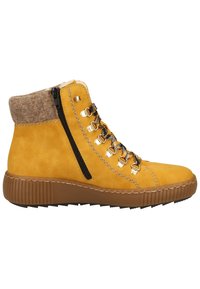 Bottine en suède jaune avec une semelle en caoutchouc marron, dotée d'une fermeture éclair, d'œillets dorés et d'un revers en laine beige en haut.