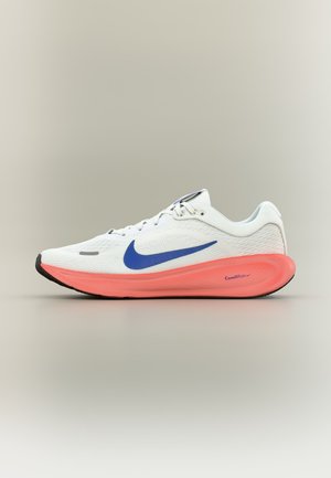 Biały but do biegania marki Nike z niebieskim znakiem i koralową amortyzowaną podeszwą ComfiRide, pokazany z profilu na neutralnym tle.
