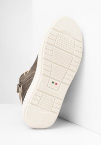 Scarpa in pelle marrone con suola in gomma bianca, dotata di zip e dettagli con logo. Motivo testurizzato visibile sulla suola.