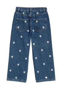 Jeans de mezclilla con un corte relajado, cinturilla elástica y margaritas blancas bordadas esparcidas sobre un fondo azul oscuro.
