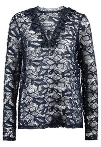 Blouse en dentelle bleu marine à manches longues avec motif floral et col en V à volants, tissu semi-transparent.