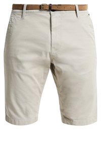 Shorts beige longueur genou avec poches avant et ceinture en cuir marron avec boucle métallique.
