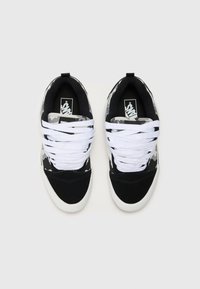 Schwarz-weiße Sneakers mit einem Muster in Schwarz und Grau und weißen Schnürsenkeln. Das Design zeichnet sich durch ein Materialmix aus Wildleder und Canvas, eine abgerundete Zehe und ein Logo auf der Zunge aus.