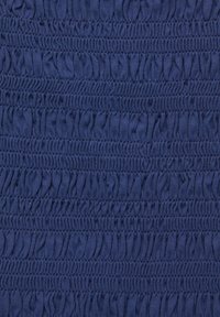 Strukturert marineblåt stoff med samlet, elastiske sektioner, der danner et ribbet mønster. Glat finish; blødt materiale; ensartet farve hele vejen igennem.