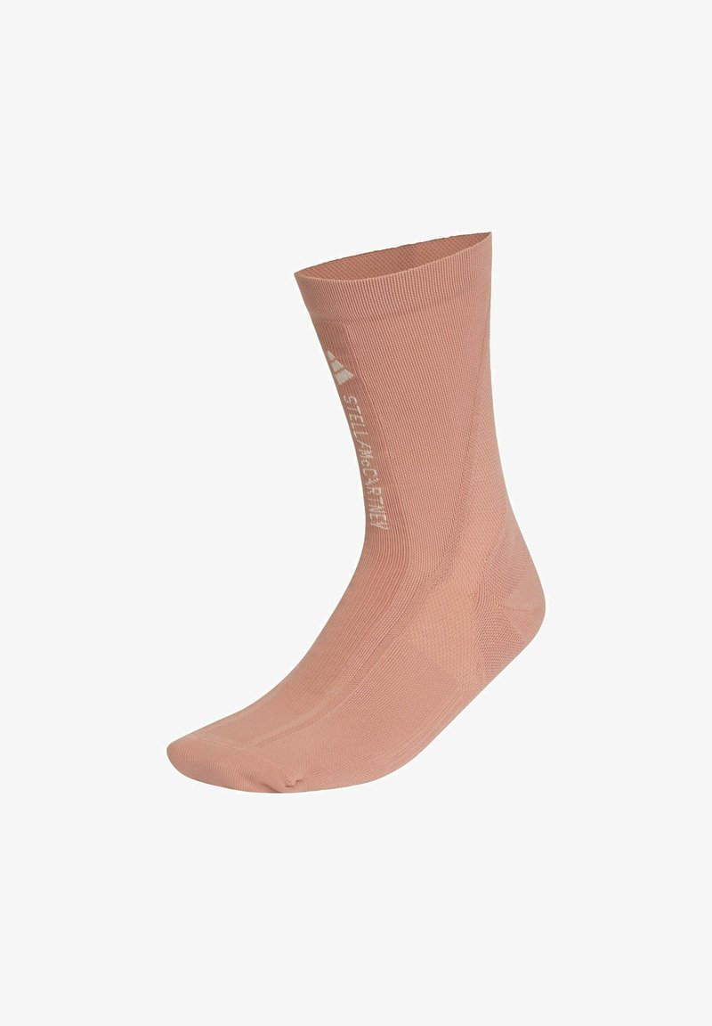 Light pink ankle sock made of a textured fabric. Features a seamless toe and branding in white on the side. Smooth, fitted design.
