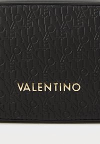 Sac en cuir noir avec un motif en relief du logo "Valentino", de forme rectangulaire élégante et avec un détail de marquage en doré.