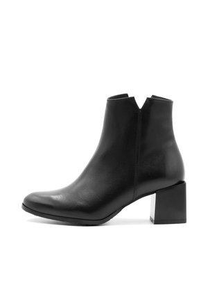 Bottine en cuir noir à bout pointu, avec un talon bloc et un décolleté en V à la cheville, présentant une texture lisse et un design minimal.