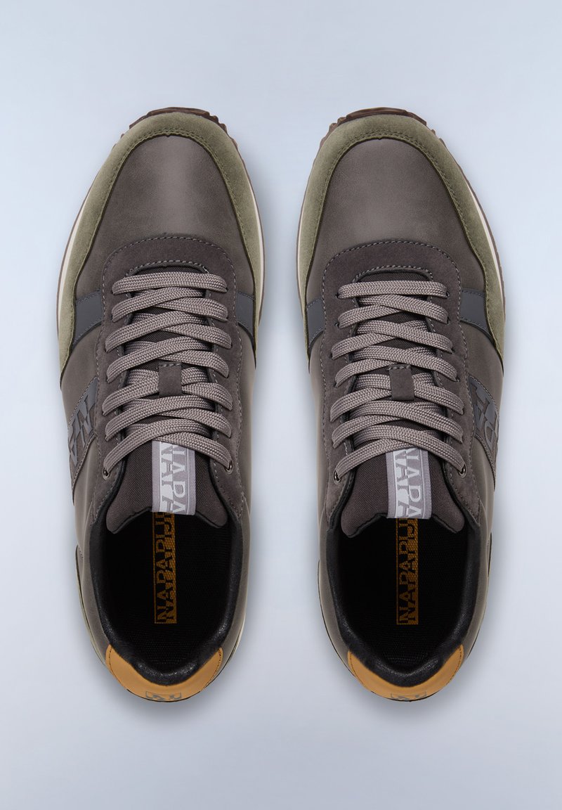 Zapatillas gris y oliva con una parte superior lisa, cordones tonales y detalle de logo. Presentan un destacado acento marrón claro en el talón y una suela de goma.