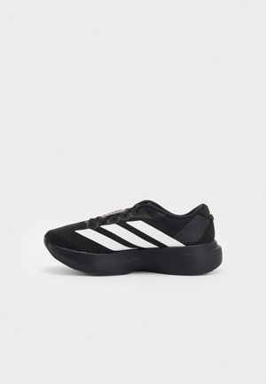 Chaussure de course noire avec une semelle épaisse et trois rayures blanches sur le côté, présentée en profil gauche sur fond blanc.