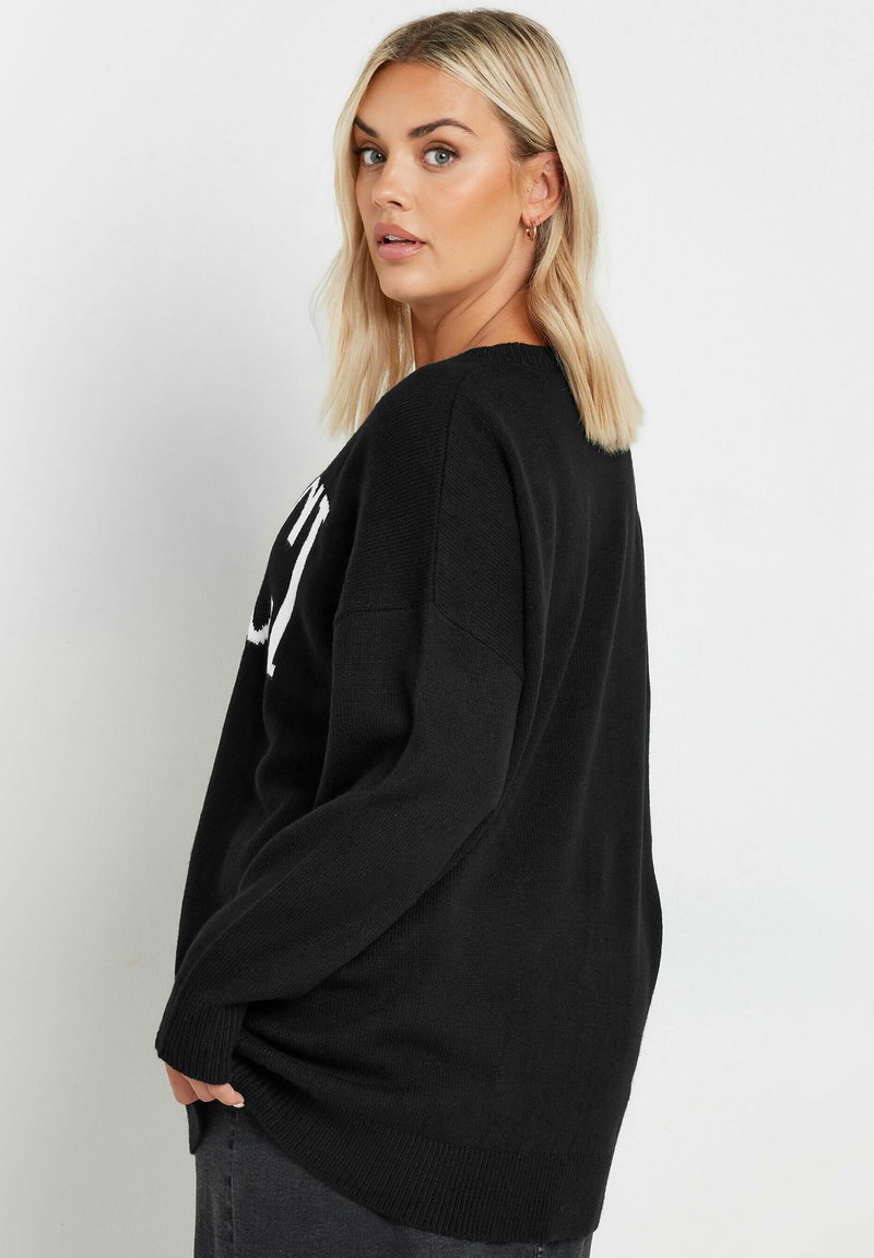 Svart stickad tröja med avslappnad passform, ribbad nederkant och ärmslut, med vit text på framsidan. Mjuk textur, rundad halsringning.