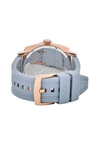 Gaiši zila silikona pulksteņu josta ar rozā zelta metāla akcentiem. Iekļauts reljefs aizmugurē un droša sprādze. Sīki redzama pulksteņa aizmugure.