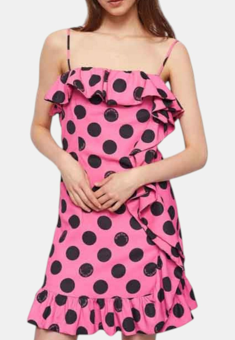 Abito senza maniche rosa con pois neri, scollatura a ruffle e dettaglio di frangia laterale, realizzato in un tessuto testurizzato.