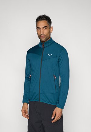 Türkisfarbige Jacke mit Reißverschluss und hohem Kragen, mit einer strukturierten Oberfläche, schwarzem Reißverschluss und orangen Akzenten an den Taschen.