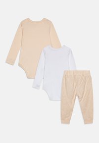 Set treh otroških oblačil: en bež bodi dolgih rokavov, en bel bodi dolgih rokavov in bež hlače s subtilnim vzorcem.