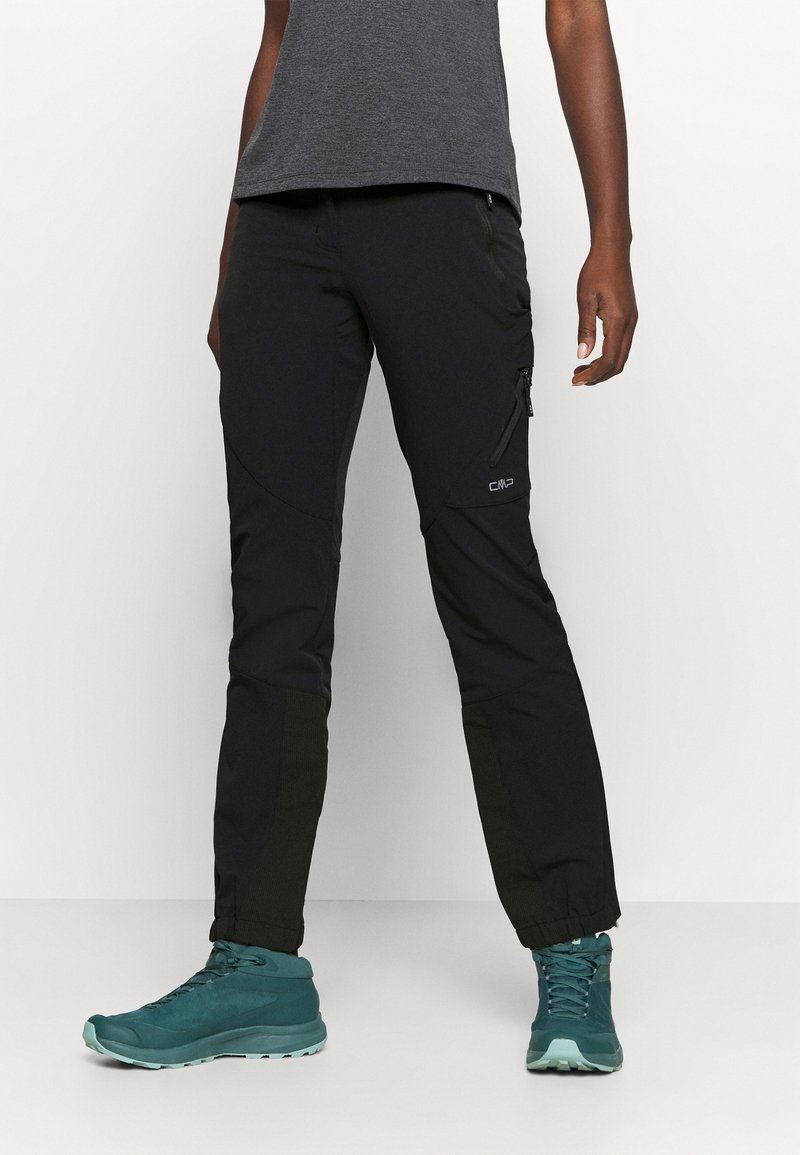 Mustat ulkoiluhousut, joissa on istuva malli, taskut ja teksturoidut yksityiskohdat, yhdistettyinä teal-värisiin vaelluskengiin.