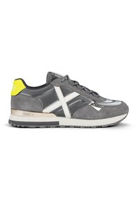 Gray sneaker featuring suede and smooth leather, white cross detail, yellow accent on heel, and a grey and white sole.