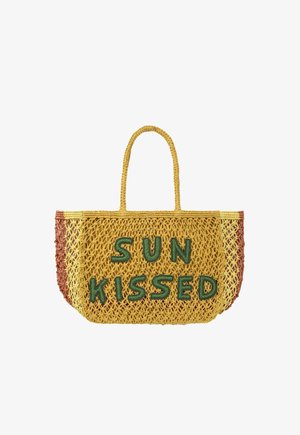 Sac cabas jaune au crochet avec des lettres vertes formant "SUN KISSED", avec des poignées tissées et des côtés rayés marron et jaune.