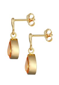 Boucles d'oreilles pendantes en ton doré, ornées d'une pierre précieuse orange en forme de goutte, avec une surface lisse et une finition brillante, le tout sécurisé par un système de fixation.