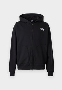 Black zip-up hoodie with a lined hood, side pockets, ribbed cuffs and hem, featuring a white logo on the left chest. Smooth fabric texture.