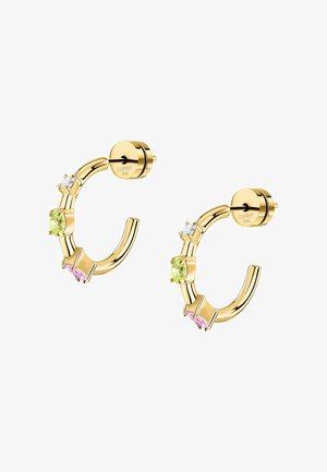 Guldtonade metallringar med tre färgade stenar: två gröna och en rosa, prydda med klara accenter. Klassisk och modern design.