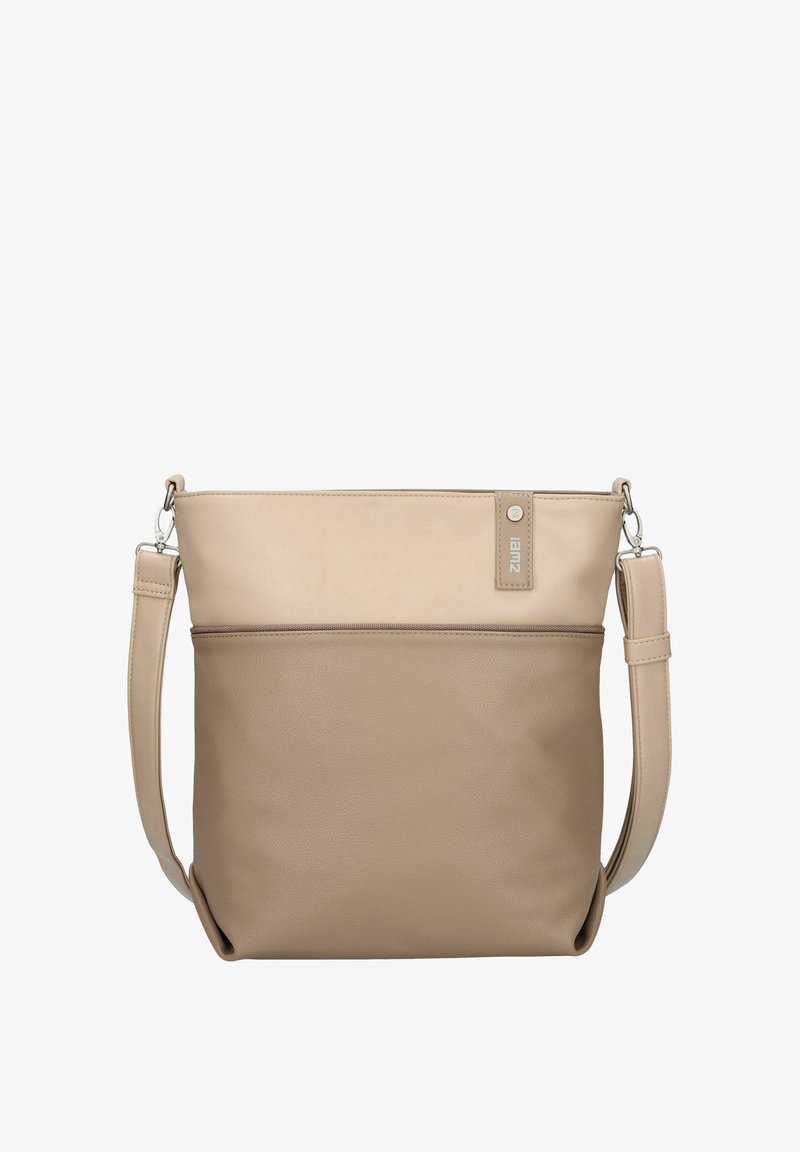 Sac bandoulière bicolore beige et taupe avec sangle ajustable, poche avant zippée et petite étiquette logo verticale près du bord supérieur.