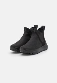 Bottines noires à tige en daim et panneaux latéraux élastiques. Dotées d'une semelle en caoutchouc texturé offrant une bonne adhérence, conçues pour la stabilité et le confort.