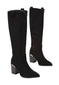 Bottes noires en suede à hauteur de genoux, avec un bout pointu, une fermeture éclair sur le côté et un talon épais avec une accent diagonal pour plus de détails.