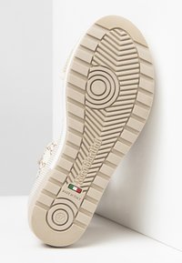 Beige gummisko-såler med tekstureret slidbane; har "NeroGiardini" branding og "made in Italy" label. Størrelse 37 er angivet.