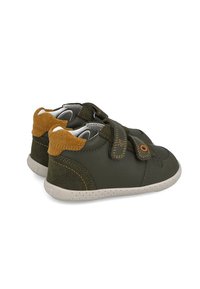 Zapatos para toddlers de cuero y gamuza verdes con correas de Velcro, punteras redondeadas, suelas blancas con lunares y acentos marrones en contraste.