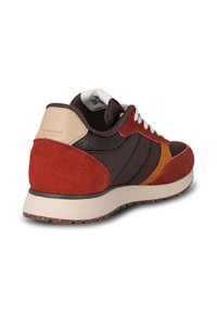 Red and brown sneaker with suede and textured materials, white laces, beige accents, and a rubber sole featuring a patterned tread.