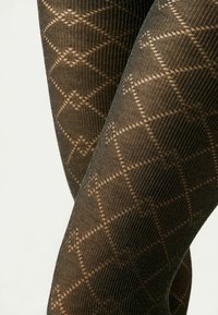 Collant neri con motivo a diamante e quadrato, caratterizzati da una texture a coste di un colore marrone scuro.